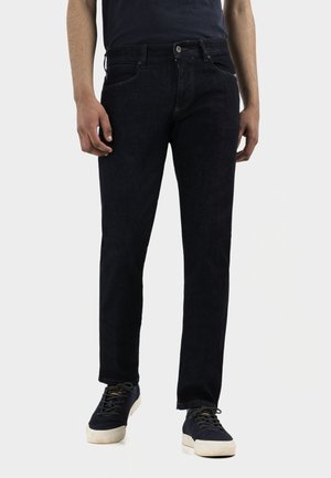 Dark blue denim jeans with a straight cut, five-pocket design, and subtle stitching details, paired with casual sneakers.