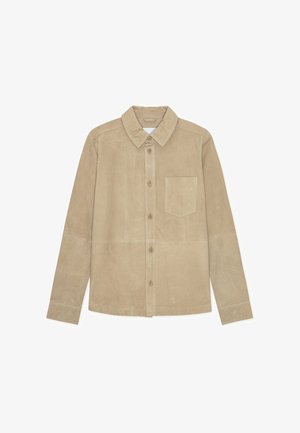 Bézs bőr ing gombos elülső résszel, hosszú ujjakkal és egyetlen mellzsebbel. Sima textúrájú és klasszikus gallér kialakítású.