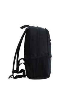 Mochila negra con cremalleras dobles, lados acolchados y correas ajustables. Cuenta con un bolsillo de malla en un lado y una textura de tela suave.