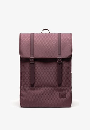 Sac à dos bordeaux en tissu à motif losange, poignée supérieure, grand rabat et deux sangles verticales à boucle sur le devant.
