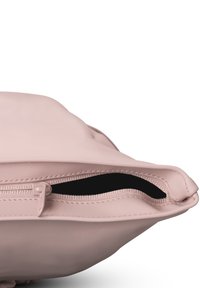 Rosa silikonväska med dragkedjestängning, med en slät textur och rundad form. Inuti är den svart, vilket kontrasterar med utsidan.