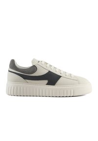 Sneaker con tomaia in pelle bianca e accenti in suede grigio, caratterizzata da una spessa suola bianca con nervature verticali e lacci piatti.