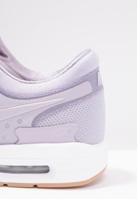 Ljuslila sneakers i mesh och syntetiska material, rund halsringning och en vit mellansula med en luftdämpningsenhet.