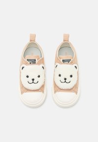 Zapatillas de tela rosa claro con caras de osito de peluche blancas en los laterales, con un acabado texturizado y suelas de goma blanca.
