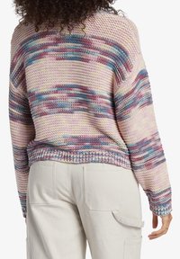 Monivärinen neulepusero, jossa löysä malli ja teksturoitu viimeistely pastellinsävyissä, kuten vaaleanpunainen, sininen ja violetti, sekä leveä pyöreä pääntie.