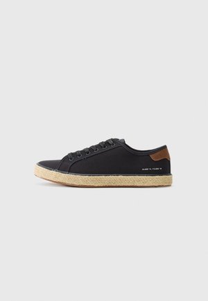 Baskets en toile bleu foncé avec bout rond, fermeture à lacets à l'avant et accent en cuir marron. Présente une semelle texturée de style espadrille.