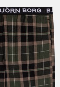 Rutet boxershorts i mørk grønn, svart og beige med en svart midje med hvit "BJÖRN BORG"-logo. Mykt stoff, avslappet passform.