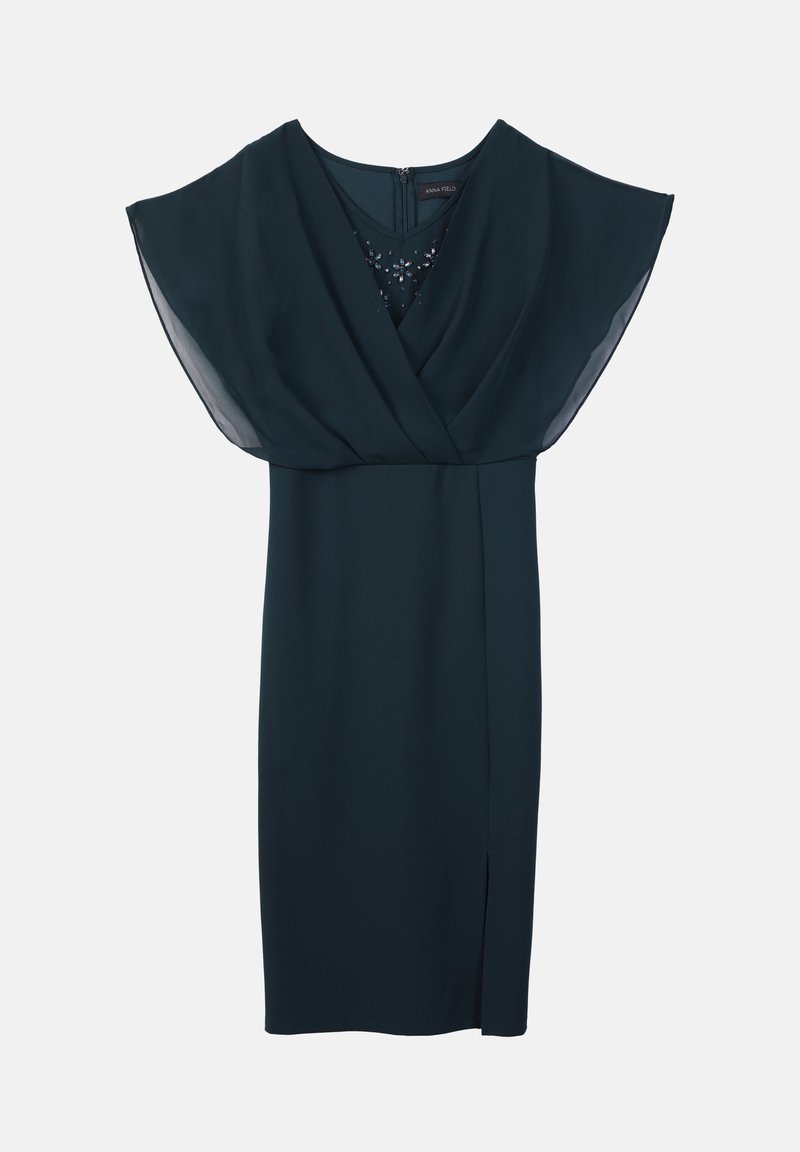 Donkergroene jurk met een wikkel-achtige bodice, korte fladdermouwen en een zijspleet. Gladde stof met een subtiele glans, ritssluiting aan de achterkant.