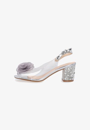Srebrny but na obcasie typu slingback z przezroczystą cholewką, ozdobionym obcasem typu blok i szarą materiałową kwiatką na pasku przy palcach.