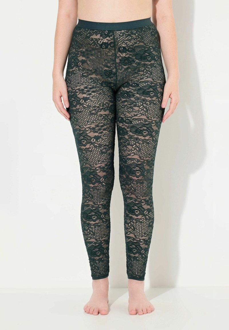 Kantleggings in donkergroen met bloemenpatronen. Ze hebben een hoge tailleband en een aansluitend ontwerp, dat de ingewikkelde kanttexturen toont.