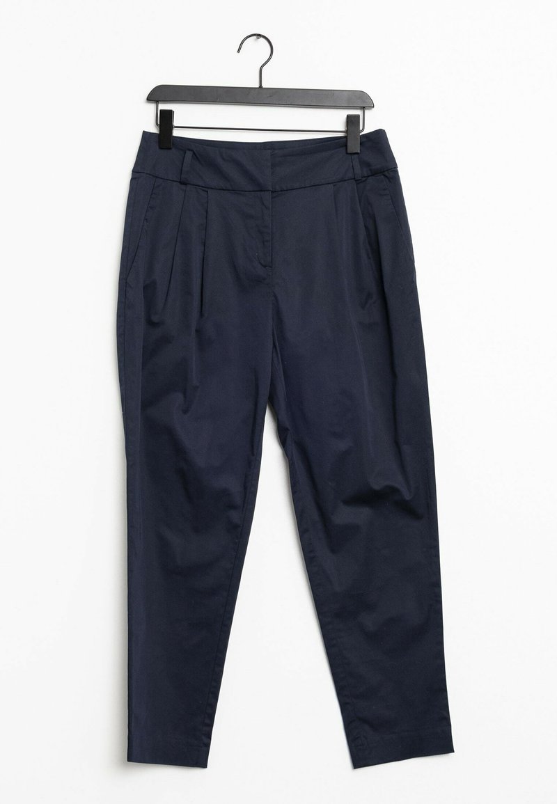 Pantalon bleu marine fuselé avec plis et poches latérales, suspendu sur un cintre en plastique noir devant un fond blanc.