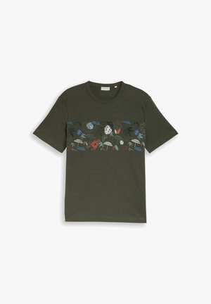 T-shirt verde scuro a maniche corte con una fascia orizzontale di foglie e piante tropicali in blu, bianco, rosso e nero sul petto.