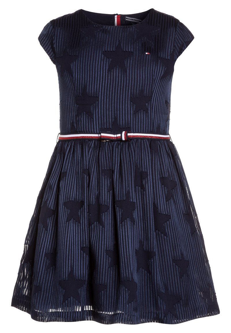 Robe marine avec un corsage ajusté, des manches courtes, des motifs d'étoiles et une jupe plissée. Comprend une ceinture rayée blanche et rouge pour l'accentuation.