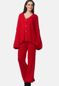 Set di abbigliamento da casa lavorato a maglia rosso, composto da un cardigan a vestibilità ampia con grandi bottoni e maniche larghe, abbinato a pantaloni texturizzati coordinati.