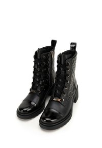 Black ankle boots with quilted texture, gold accents, round toe, and chunky heel. Features laces and a side zipper for easy wear.