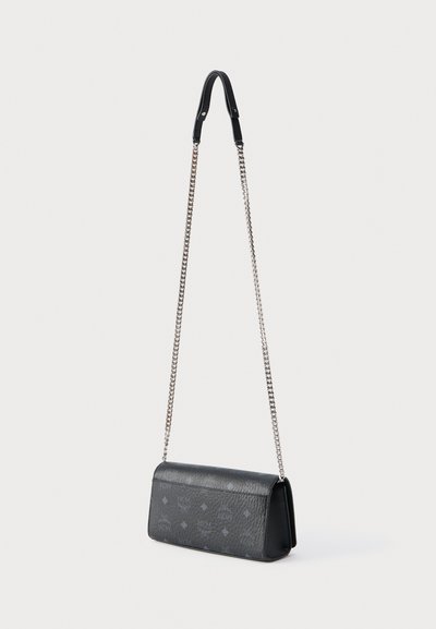 Μαύρη υφασμάτινη τσάντα ώμου από δέρμα με ασημένιο λουρί αλυσίδας και διακριτικό ανάγλυφο σχέδιο, ορθογώνιο σχήμα, στέκεται όρθια σε λευκό φόντο.