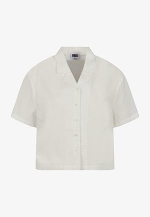 Kortermet, kragebluse i hvitt laget av teksturert stoff med knapplukking foran. Har klare knapper og en avslappet passform.