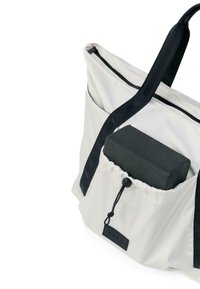 Pelēka somiņa ar melniem akcentiem, kurai ir augšējais rāvējslēdzējs, auklas kabata un izturīgi plecu siksnas ērtai pārvadāšanai.