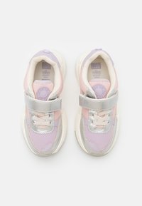 Zapatillas en rosa y lavanda con acentos plateados, materiales de tela y sintéticos, cuello acolchado, cordones y correa ajustable. Plantilla de espuma con memoria.