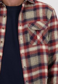 Geverfd flanellen overhemd in rood, marineblauw en beige; knoopsluiting met een borstzak. Zachte textuur en opvallend ruitpatroon.