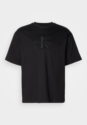 T-shirt nera a maniche corte di Calvin Klein con logo in rilievo "cK Calvin Klein" di colore nero centrato sul petto.