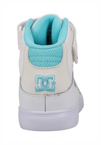 Białe wysokie trampki z teksturowanym wykończeniem i turkusowymi akcentami. Posiadają wyściółkę w okolicy kostki, rzep oraz logo DC w kolorze turkusowym.
