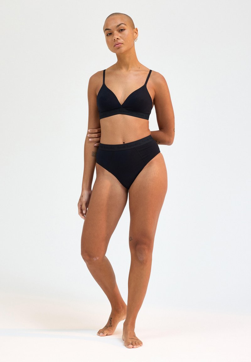 Set composto da reggiseno nero e bikini a vita alta realizzati in tessuto liscio. Il reggiseno presenta una scollatura profonda e spalline regolabili, con una fascia decorata con logo.