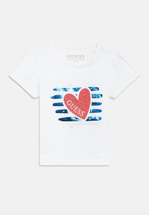 Weißes Kleinkind-T-Shirt mit blauen horizontalen Streifen und einem großen roten glitzernden Herz mit dem Wort "GUESS" in der Mitte.