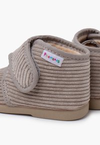 Stivali in tessuto grigio con texture a coste, chiusura in Velcro e fodera morbida. Presentano un'etichetta "pisamonas" multicolore sul lato. Suola piatta in gomma.