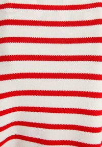 Weißer Stoff mit gleichmäßig verteilten horizontalen roten Streifen, die ein Strickmuster bilden und Textur sowie Maschendetails zeigen.