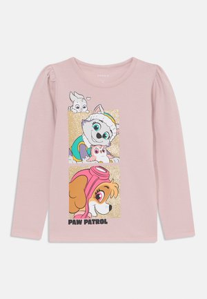 Dlhý rukáv ružové tričko s tromi kreslenými postavičkami v trblietavom dizajne. Na spodnej časti je text "PAW PATROL". Mäkká bavlnená tkanina.
