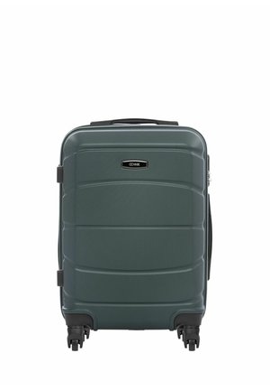 Ciemnozielona walizka z twardą skorupą, wyposażona w cztery obrotowe kółka i górny uchwyt, widoczna od przodu z prostokątną etykietą marki w pobliżu środka u góry.