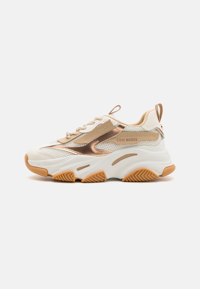 Baskets blanches épaisses avec des accents beige et or rose métallisé, semelle épaisse avec une accroche beige texturée et marquage "Steve Madden" sur le côté.
