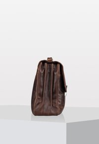 Mochila de cuero marrón con una textura suave, forma redondeada y diseño plisado; cuenta con un asa superior y acentos de hardware en plata.