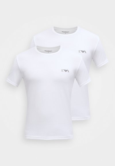 Dvě bílé bavlněné trička s krátkými rukávy, kulatými výstřihy a černým logem na levé straně hrudi. Hladká textura, klasický střih.