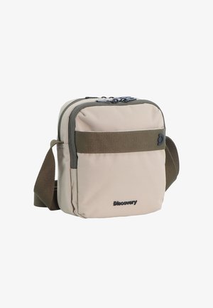Kompakte beige Umhängetasche mit dunkelgrünem Gurt, vorderer Reißverschlusstasche und "Discovery"-Logo auf der unteren Vorderseite.
