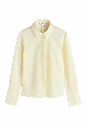 Langärmliges, blassgelbes Hemd mit klassischem Kragen und verdeckter Knopfleiste vor weißem Hintergrund.