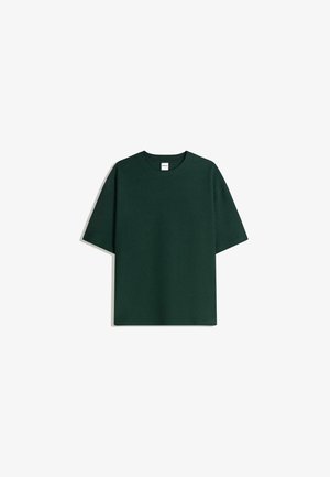 Dunkelgrünes Baumwoll-T-Shirt mit Rundhalsausschnitt und kurzen Ärmeln. Einfaches Design, reguläre Passform, glatte Textur, keine Muster oder Akzente.