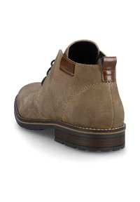 Bottes chelsea en daim marron avec un accent brillant marron au talon, design à bout rond et coutures contrastantes sur la semelle en caoutchouc.