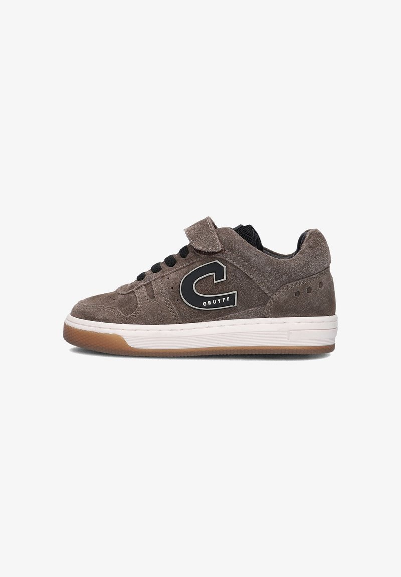 Bruine suede sneakers met zwarte accenten, voorzien van een klittenbandsluiting en zwarte veters. Witte tussenzool en gumrubberen buitenzool met geperforeerde details.