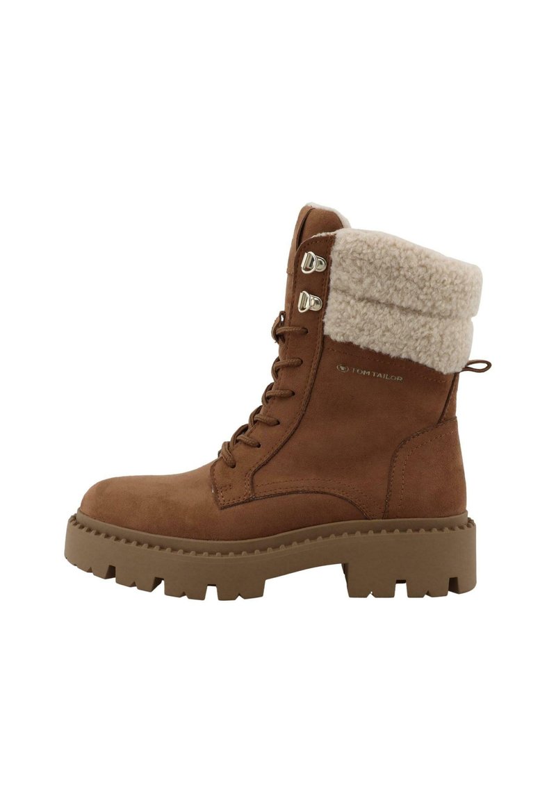 Brune ruskinds ankelstøvle med fluffy beige krave, kraftig beige sål og metaløjer. Har et logo på siden.