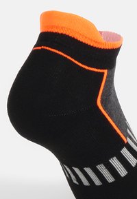 Calzino sportivo nero con un bordo e dettagli arancioni, tallone strutturato e strisce grigie riflettenti lungo il lato per una maggiore visibilità.