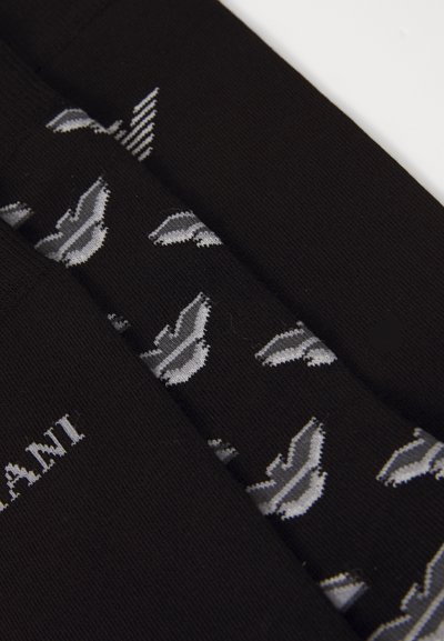 Black socks featuring a repeated gray leaf pattern, with a ribbed texture and a light logo on one side. Cotton blend material.