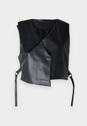 Musta hihaton keinonahkaliivi leveällä kauluksella ja epäsymmetrisellä etukappaleella, sivuilla metallirenkailla varustetut hihnat.