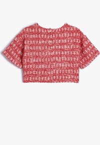 Punainen lyhyt crop-top, joka on valmistettu kudotusta kankaasta, ja siinä on teksturoitu kuvio valkoisilla yksityiskohdilla sekä lyhyet hihat. Pyöreä pääntie, jossa on nappikiinnitys.