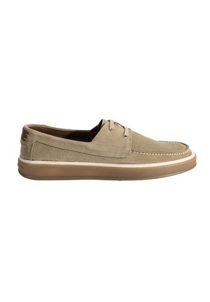 Chaussures en suede beige avec une silhouette basse, dotées de deux œillets, d'une couture blanche et d'une semelle en caoutchouc avec un léger talon.