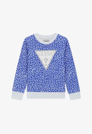 Niebieska koszula z długim rękawem z białym kwiatowym wzorem, białym kołnierzykiem i mankietami oraz dużym srebrnym trójkątem z logo Guess umieszczonym centralnie na przodzie.