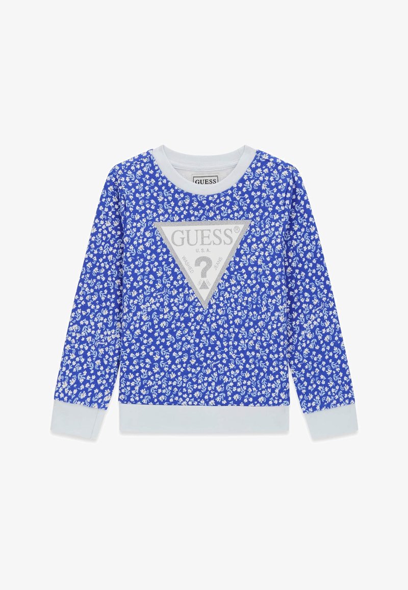 Chemise bleu à manches longues avec motif floral blanc, col et poignets blancs, et un grand triangle logo Guess argenté centré sur le devant.