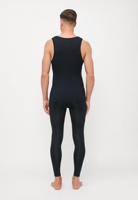 Sæt bestående af sort tanktop og leggings, lavet af strækbart stof. Tanktoppen har rund hals; leggings sidder tæt til kroppen, begge er sømløse.