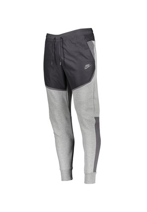 Grå og sorte Nike joggebukser med snor i taljen, elastiske manchetter, sidelommer og reflekterende logo på øverste lår.